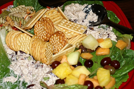 Buffet spread with crackers, chicken salad, pasta salad and fresh fruitの写真素材