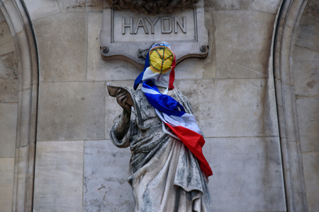 Protesters of Yellow Vests demonstration (Gilets Jaunes) against fuel tax, government, and French President Macron put yellow vest and flag on Paris Opera Garnierのeditorial素材