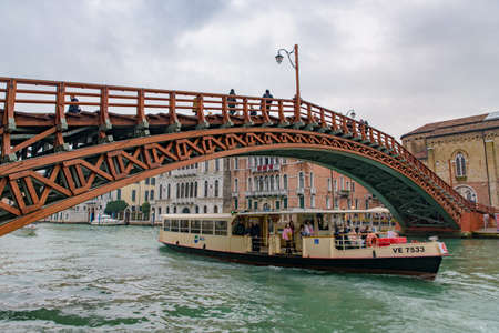 A vaporetto (waterbus) on the Grand Canal passing Accademia Bridge (Ponte dell'Accademia) in Venice, Italyのeditorial素材