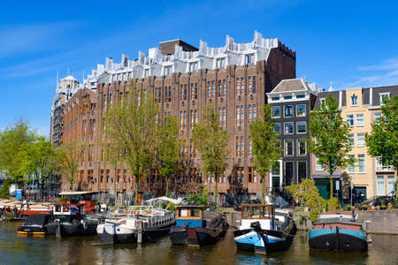 Buildings and boats along the canal in Amsterdam, Netherlandsの写真素材