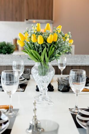 Dining table close up, With a beautiful black palette And clear flower vases and black candlestick Have a clear wine glass Beautifully pairedの写真素材