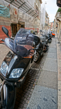 One of down town street in the city center of Verona, Italy, Cars and motos are parking in a line.のeditorial素材