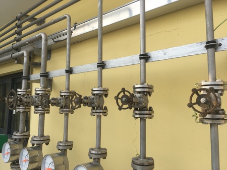 Valve with hand wheel, tubes, and flanges fitting in a factoryの写真素材