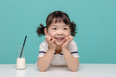 Little pretty Asian girl laughing portrait with milk, healthy and happy lifestyle.の写真素材