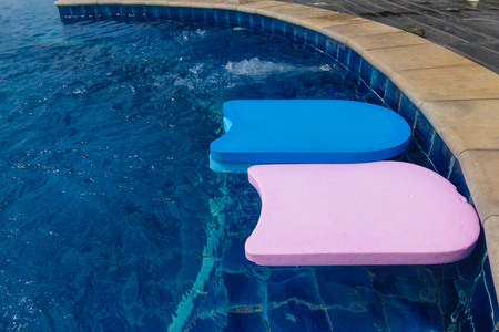 Foam board for the teaching of swimming beside swimming poolの写真素材