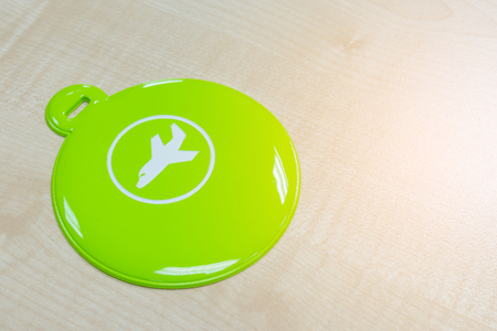 Circle green luggage tag on wooden tableの写真素材
