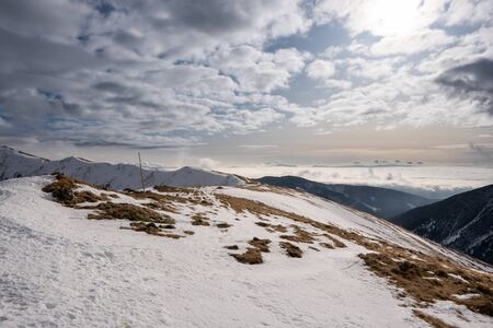 Snow covered mountains with clouds and mist in valley, Low Tatras Dumbier, Slovakiaの写真素材