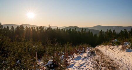 hiking trail in the mountains with the sun over the hills, czech lysa hora