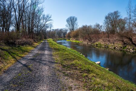 dirt road with river and trees around, in Czech Olza