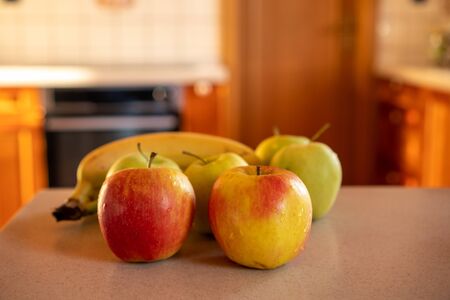 apples and bananas on the kitchen counter in the background oven and doorの写真素材