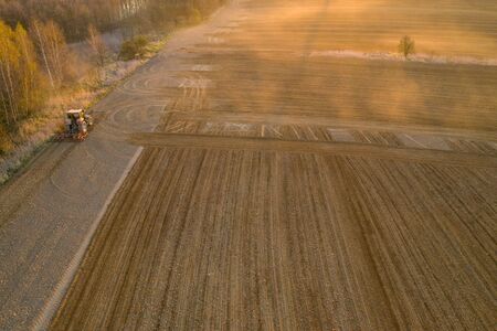 aerial shots of the tractor at sunrise while working in the field, czechの写真素材