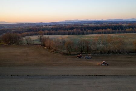 aerial shots of the tractor at sunrise while working in the field, czechの写真素材