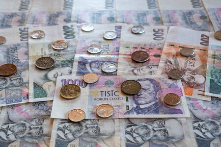 CZK banknotes and coins stacked side by side