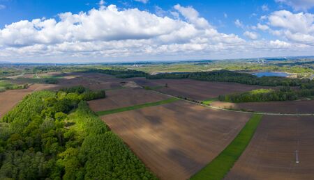 aerial view of fields and forests in spring with beautiful cloudsの写真素材
