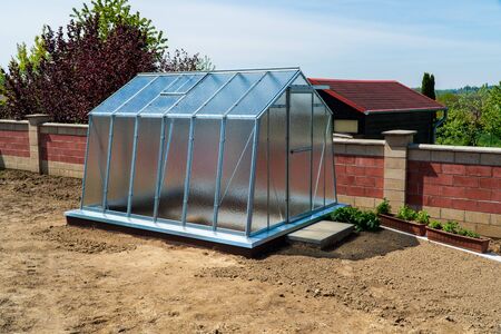 greenhouse in the garden with brown soil aroundの写真素材