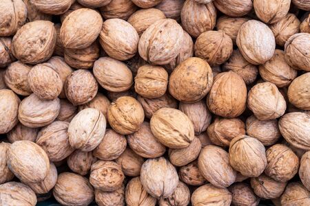 Natural walnut background pattern texture Abstract walnuts heap pattern background Blurred edges frame Natural food in-shell nuts walnuts pattern backdrop Walnuts in shell background dramatic contrastの写真素材