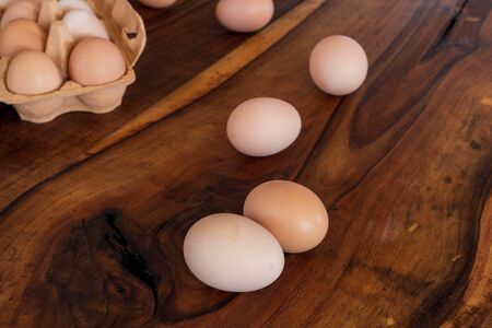 Detail close-up of chicken eggs in egg box on the old brown wooden background.の写真素材