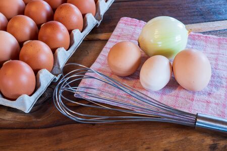 fresh brown and white chicken eggs on a plate on wooden backgroundの写真素材