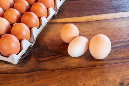 Detail close-up of chicken eggs in egg box on the old brown wooden background.の写真素材