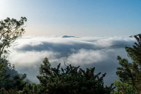 the light of the setting sun illuminates a landscape immersed in fog and clouds, mountains and valleys with lingering mist, Madeiraの写真素材