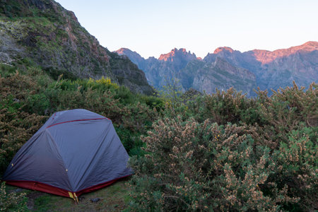 Gray camping tent on top of mountain with amazing sunrise on background. Time spending on fresh air. Traveling concept. Madeira islandの写真素材