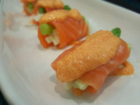 Salmon sushi roll on white plateの素材