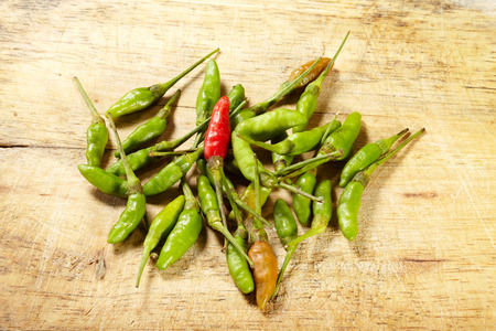 Red and green chilli on wood backgroundの写真素材