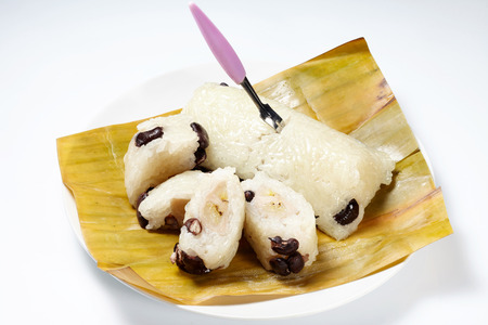 Traditional Thai dessert Glutinous rice streamed with banana wrap banana leaf. Khao Tom Mat isolated on white backgroundの写真素材