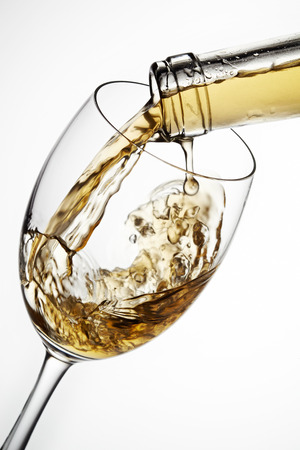 Glass of wine with splash, isolated on white backgroundの写真素材