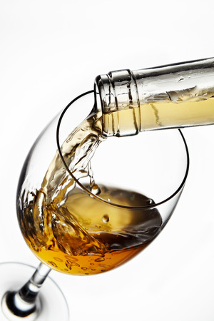 Glass of wine with splash, isolated on white backgroundの写真素材