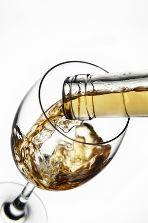 Glass of wine with splash, isolated on white backgroundの写真素材