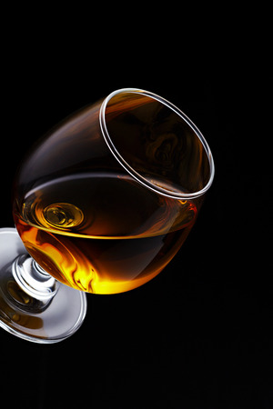 Whisky on glass isolated on black backgroundの写真素材
