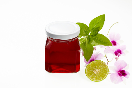 Pot of honey with lime, sweet basil and orchid isolated on white backgroundの写真素材