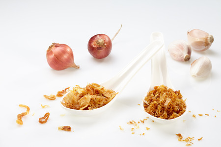 Fried garlic and onion on white spoon with garlic and onion isolated on white backgroundの写真素材