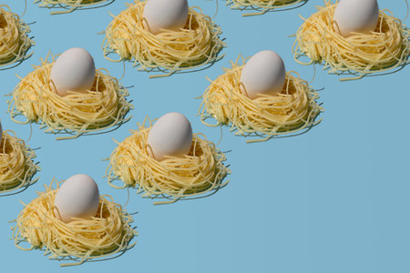 Creative layout made of pasta nests and eggs on blue background. Minimal easter concept.の写真素材
