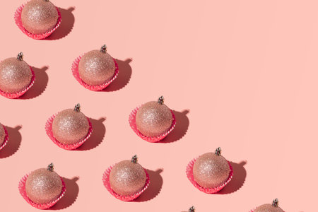 Christmas baubles in cupcake liners, creative pattern on pastel pink background.の写真素材