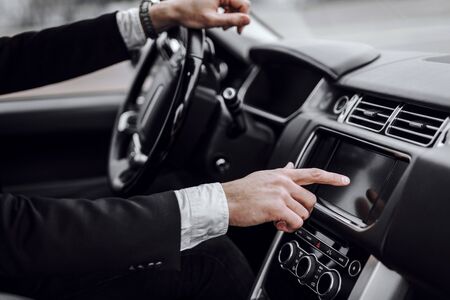 Close up of man driving car with audio stereo system on board computer. Transportation and vehicle conceptの写真素材