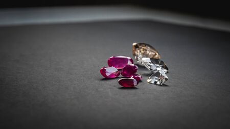 Collection of Red ruby and topaz, Precious stones for jewellery on black matte paper background, rough paperの写真素材