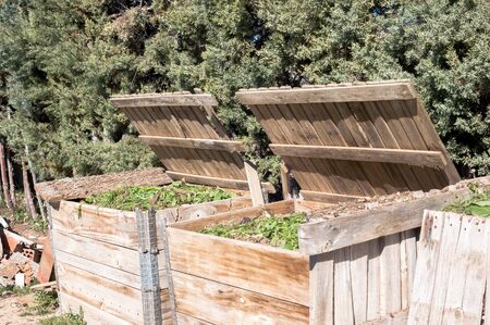 Pair of handmade wooden composters filled with organic waste. Front viewsの写真素材