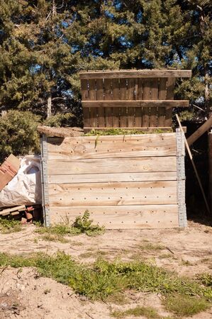 Handmade wooden composter full of organic waste. Front viewの写真素材