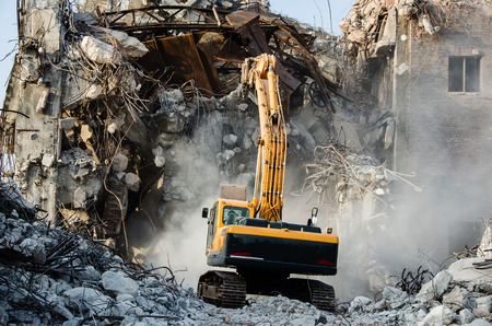 Excavator working at the demolition of an old industrial building.