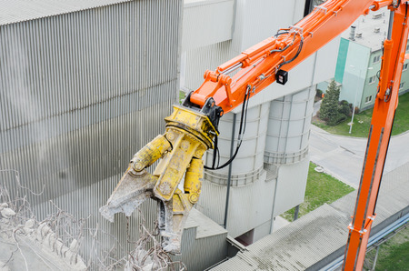 Excavator working at the demolition of an old industrial building.