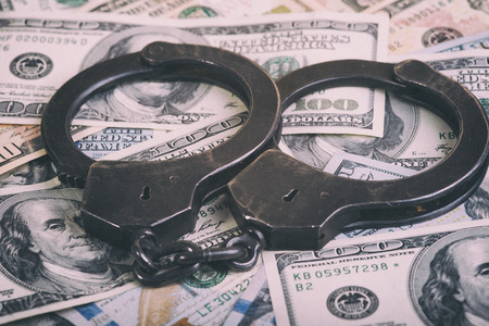 Dollars and handcuffs. Financial crime, illegal activity. Breaking the tax law.の写真素材