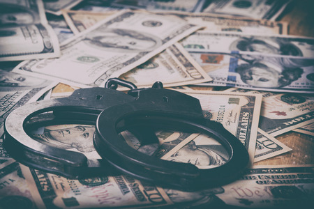 Dollars and handcuffs. Financial crime, illegal activity. Breaking the tax law.の写真素材
