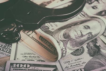 Dollars and handcuffs. Financial crime, illegal activity. Breaking the tax law.の写真素材
