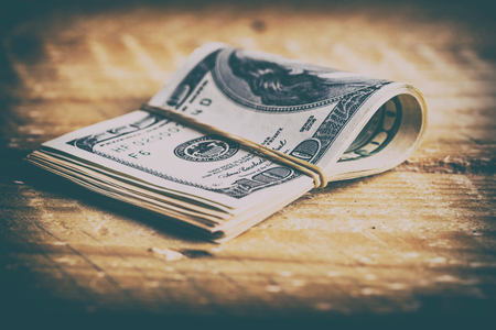 The US currency. Dollars related eraser on a wooden board.Background of success
