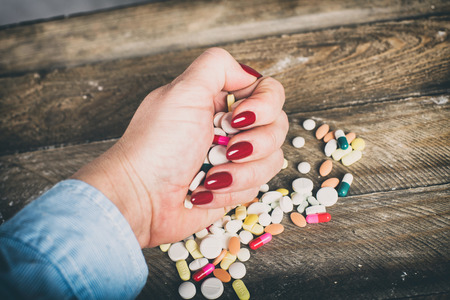 Woman taking drugs. Drugs on hand.の写真素材