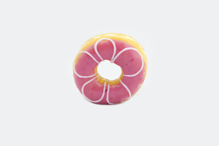 Donut with pink icing and white stripes isolated on white background. Top viewの写真素材