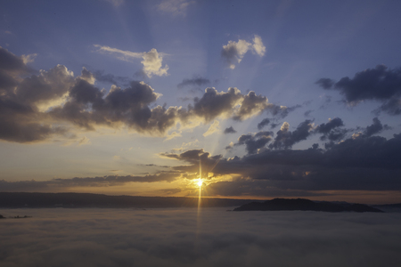 beautiful sunset in the mountains with fog and cloudsの写真素材