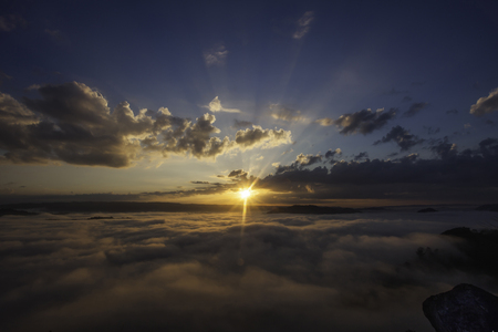 beautiful sunset in the mountains with fog and cloudsの写真素材